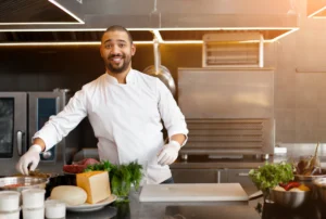 Personal meal prep chef reaching for fresh ingredients beside herbs cheese and beef