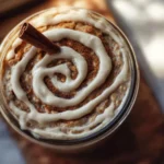 Bowl of cinnamon roll overnight oats topped with cinnamon and raisins.