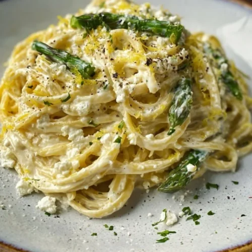 Creamy lemon feta pasta dish served in a bowl with herbs and lemon slices