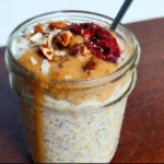 High-protein overnight oats in a bowl topped with fruits and nuts