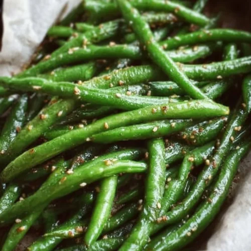 Plate of miso green beans garnished with sesame seeds and scallions