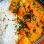 Homemade sweet potato curry served in a bowl with spices and herbs