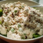 Delicious chicken salad served in a bowl with fresh vegetables and herbs