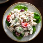 Delicious healthy chicken salad topped with fresh vegetables and herbs.