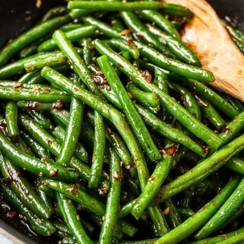 Plate of sautéed green beans with 5 simple ingredients.