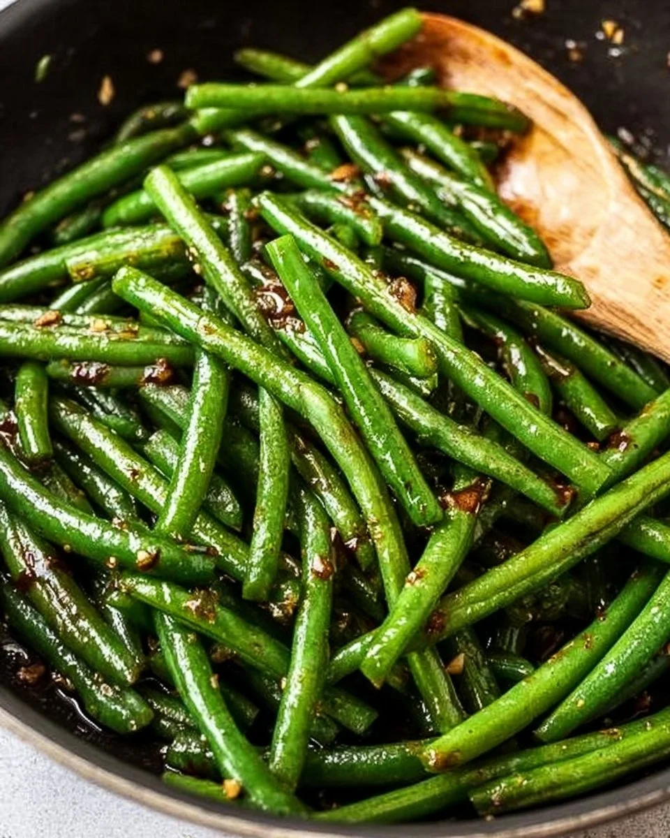 Plate of sautéed green beans with 5 simple ingredients.