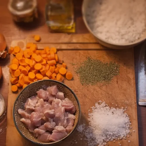 A close-up shot of hands actively cooking food in a vibrant kitchen setting
