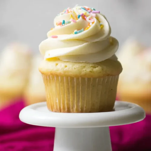 A batch of easy vanilla cupcakes on a cooling rack, ready to decorate