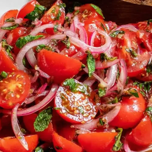 A fresh Lebanese tomato salad with vibrant red tomatoes and green herbs.