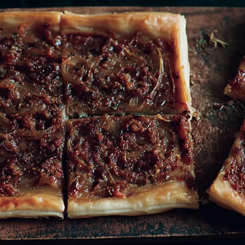 A golden-brown onion tart with caramelized onions on top.