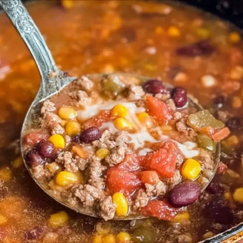 A bowl of delicious taco soup with ranch packet seasoning, garnished with fresh cilantro and cheese.