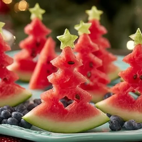 A Christmas tree made from fresh watermelon slices and fruit.