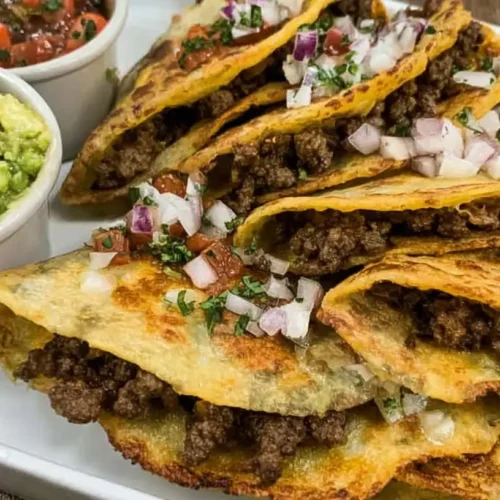 A plate of delicious crispy beef tacos filled with fresh toppings