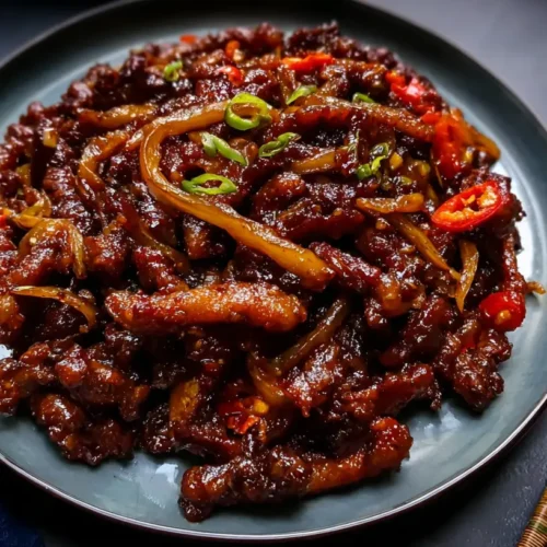 A plate of crispy chilli beef with a glossy sauce.