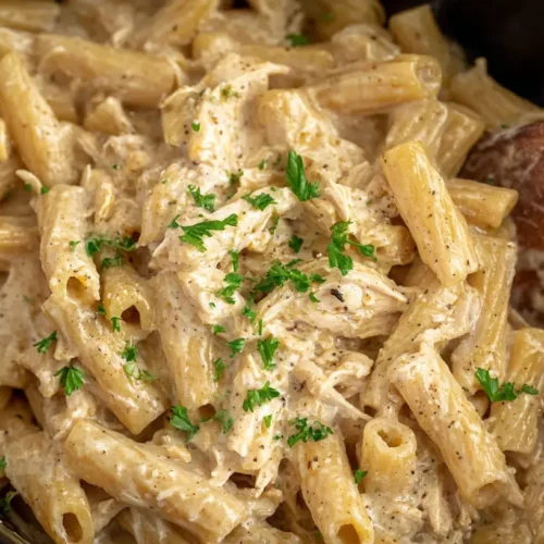 A creamy Crockpot Garlic Parmesan Chicken Pasta dish in a slow cooker, ready to serve.
