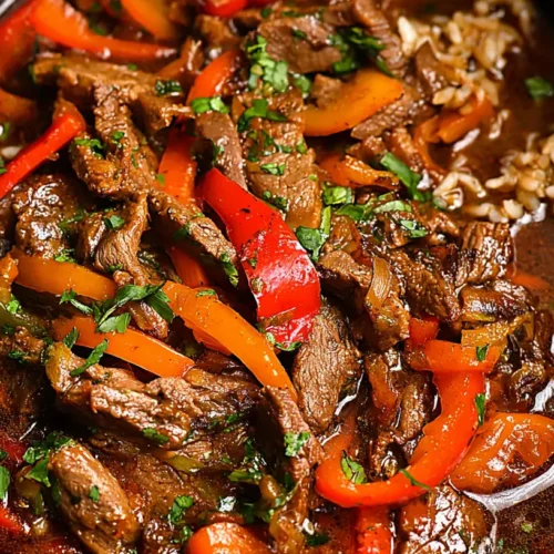 A serving of easy slow cooker pepper steak with tender beef and colorful bell peppers
