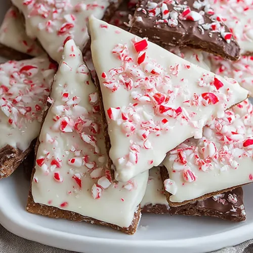 Peppermint crunch white chocolate covered graham crackers arranged on a white plate.