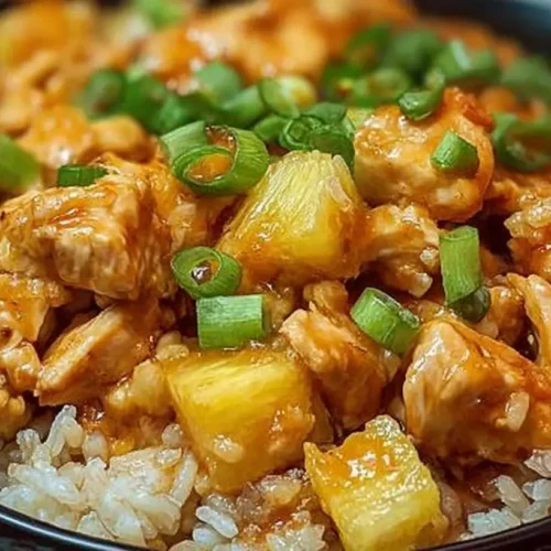 A vibrant plate of pineapple chicken and rice, showcasing colorful ingredients and a delicious glaze.
