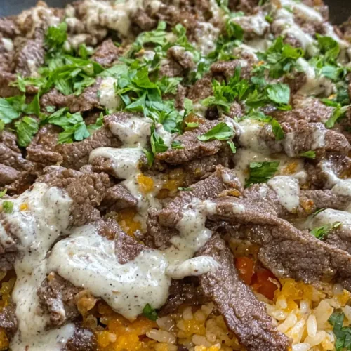 A close-up of a bowl of Steak and Cheese Rice, richly garnished.