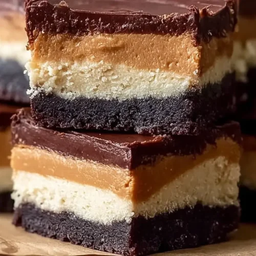Delicious chocolate peanut butter cheesecake bars on a white plate.
