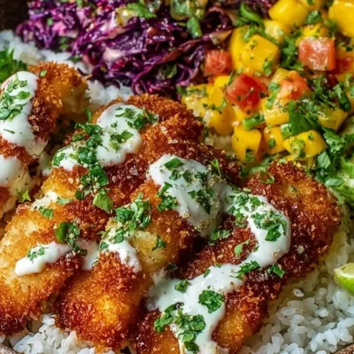 A vibrant Crispy Fish Taco Bowl with fresh toppings and a lime wedge.