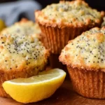 A stack of fluffy lemon poppy seed muffins on a cooling rack