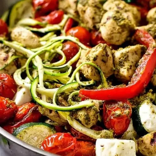 One-pan pesto chicken with zucchini and peppers, golden brown and juicy