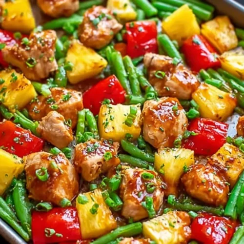 A colorful sheet pan teriyaki chicken and pineapple dish, freshly baked.