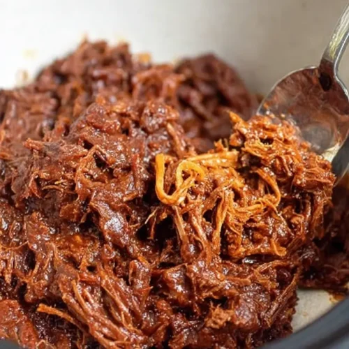A serving of crockpot BBQ pulled beef, shredded and saucy.