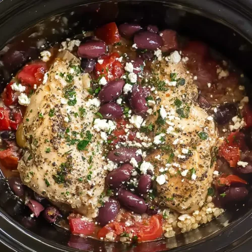 Crockpot full of Mediterranean chicken with olives and colorful vegetables