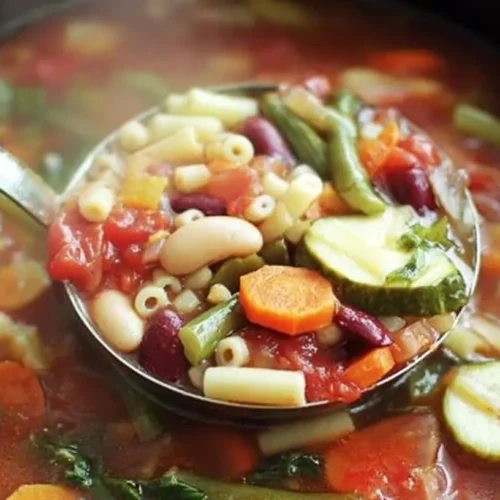 A steaming bowl of Crockpot Minestrone Soup with fresh herbs