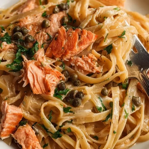 A bowl of easy salmon pasta dinner, garnished with fresh herbs.