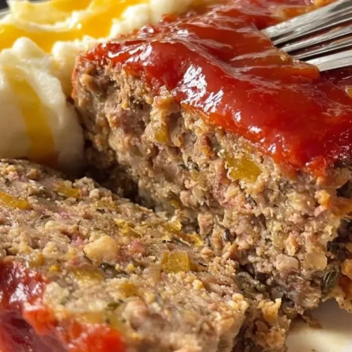A savory family favorite meatloaf, perfectly baked and sliced on a serving platter.