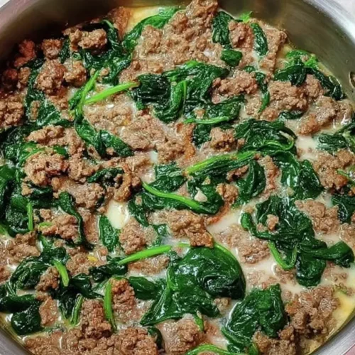 A steaming dish of ground beef and spinach prepared for dinner.