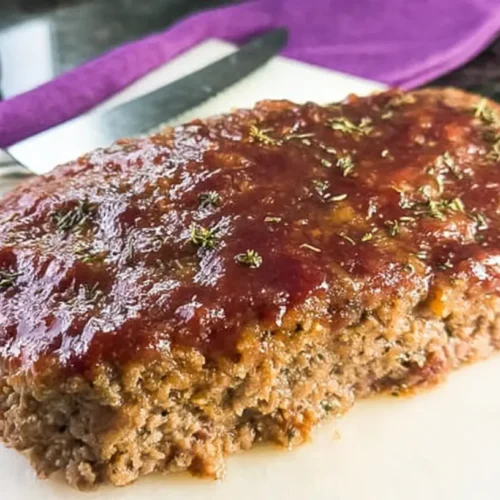 A freshly baked healthy ground beef meatloaf, perfectly sliced to show its texture.