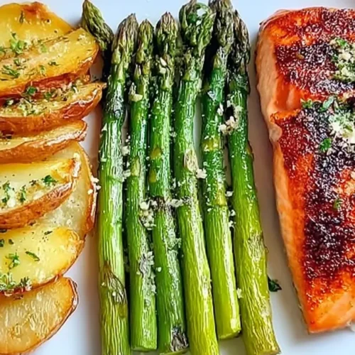 A healthy salmon dinner plate with perfectly cooked salmon and vibrant vegetables.