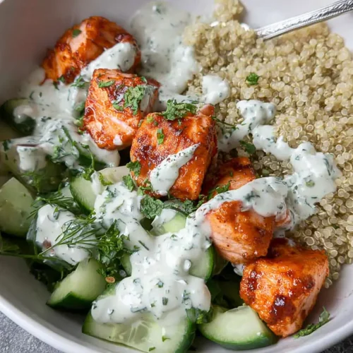 A vibrant healthy salmon and quinoa bowl with fresh vegetables.