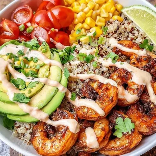 A colorful healthy shrimp bowl filled with fresh vegetables and seasoned shrimp