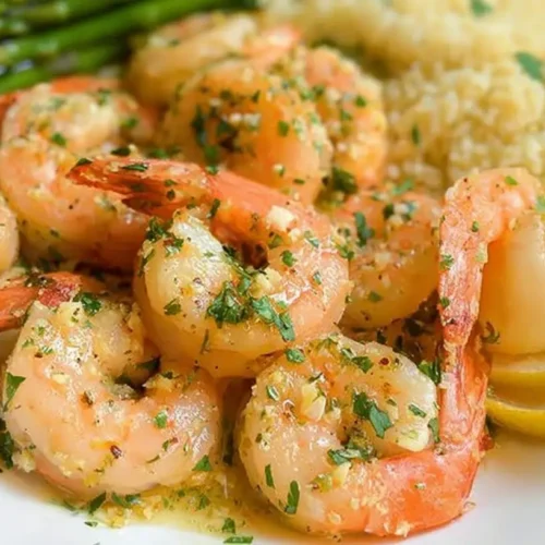 A vibrant lemon garlic shrimp plate served with fresh herbs.