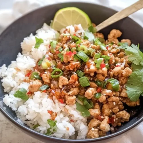 A vibrant low fat turkey rice bowl, garnished with fresh herbs and vegetables.