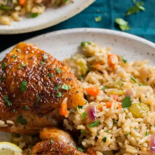 A baking dish filled with golden brown baked chicken and rice, ready to serve.