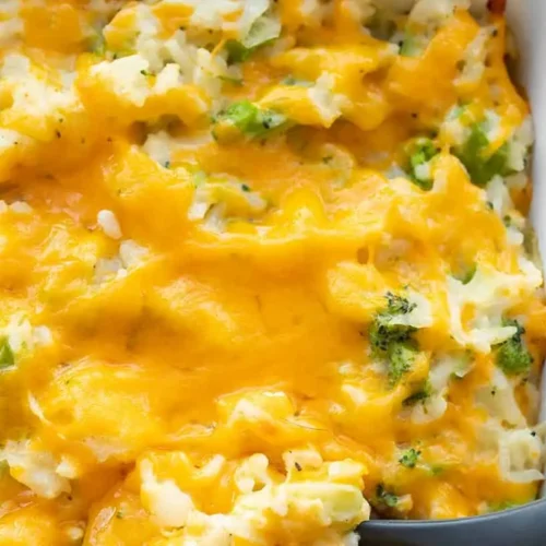 A bubbling broccoli cheese casserole fresh from the oven, showing golden-brown topping and green florets.
