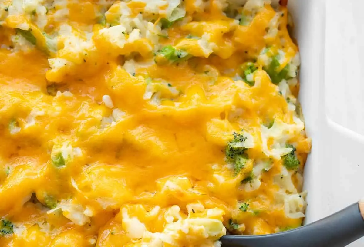A bubbling broccoli cheese casserole fresh from the oven, showing golden-brown topping and green florets.