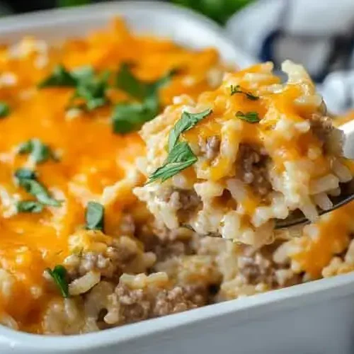 A bubbling cheesy hamburger casserole in a baking dish, fresh from the oven