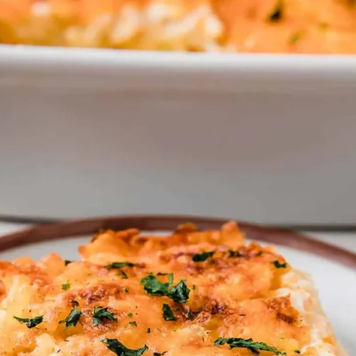 A bubbling hash brown casserole baked to golden perfection in a ceramic dish.