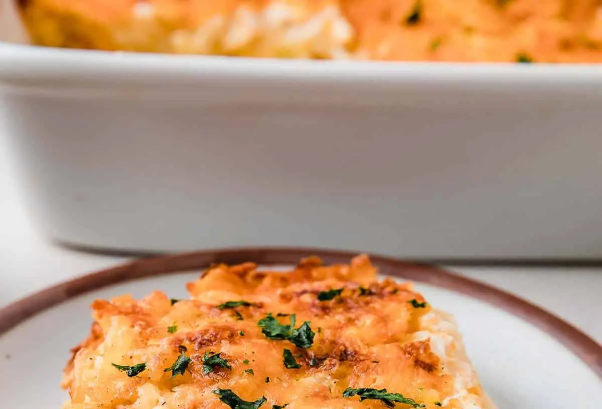 A bubbling hash brown casserole baked to golden perfection in a ceramic dish.