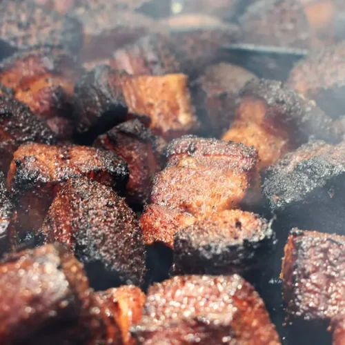 A serving of delicious Kansas City burnt ends, glistening with sauce.