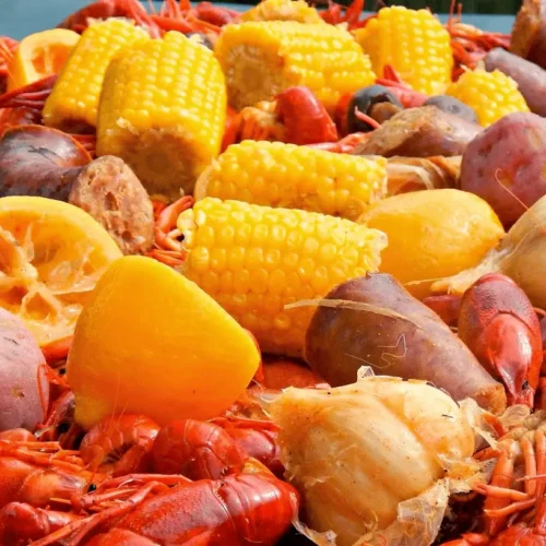 A massive pot filled with a vibrant Louisiana crawfish boil, featuring red crawfish, corn, and potatoes.