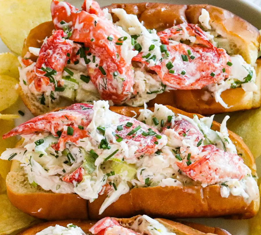 A freshly prepared Maine crab roll on a toasted bun, garnished with a lemon wedge