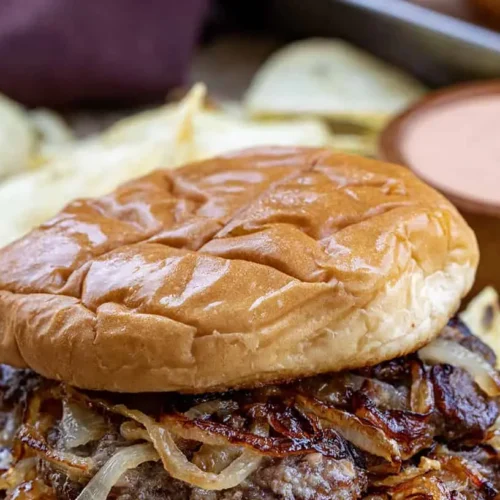 A delectable Oklahoma fried onion burger with melted cheese and pickles on a bun